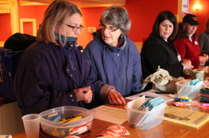 Rita Walker, second from left, explains some details to Alice Drislane at the registration table at the Paramount Theatre in Rutland. Walker, from Montpelier, is one of hundreds of Red Cross employees who have mobilized for the #GOLM13.