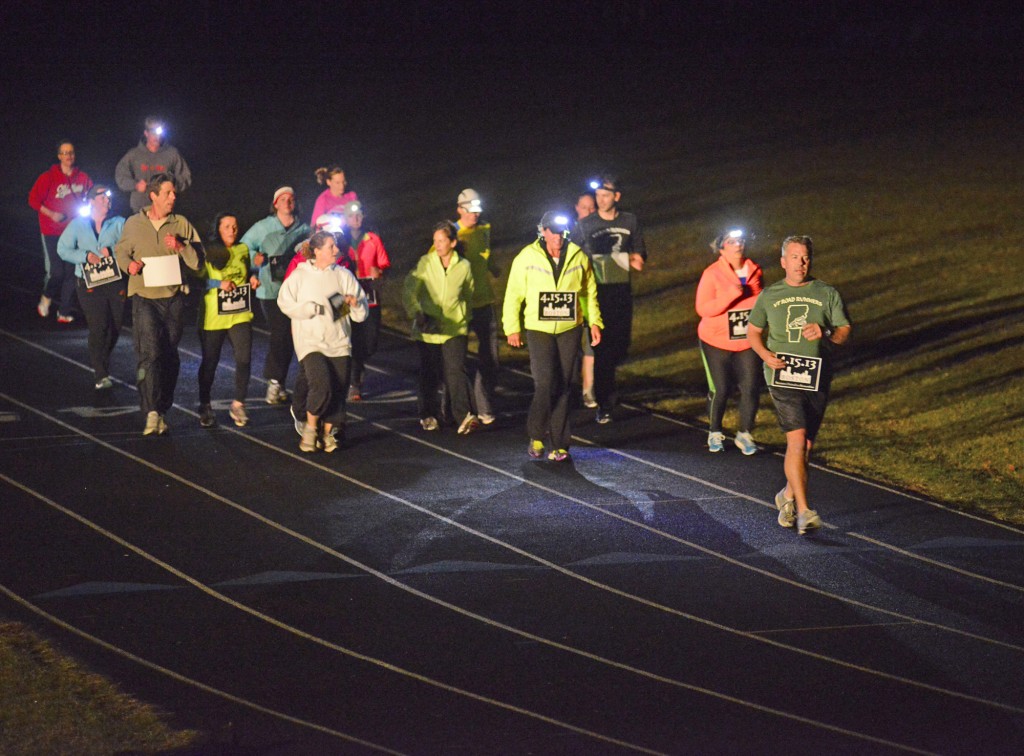 Stefan Hard / Staff Photo Some of the 32 runners at a one-mile run to remember the victims of the Boston Marathon bombings circle the track  Tuesday evening at U-32 High School in East Montpelier, where they also ran alongside April Farnham of Plainfield, who returned safe from running in Monday's Boston marathon. Runners around the nation  Tuesday also ran one mile to show their solidarity with Boston.