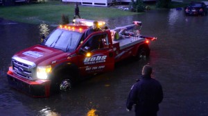 Eric Francis Photo A lightning flash reveals a flooded stretch of Gates Street in   downtown White River Junction next to the large phone company building   late Wednesday night as a tow truck operator talks to Hartford Police   Officer Sean Fernandes.