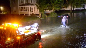 Eric Francis Photo Hartford Police Officer Sean Fernandes wades down a flooded stretch of   Gates Street near the large phone company building in downtown White   River Junction late Wednesday night after a thunderstorm flooded   several downtown streets and parking lots.